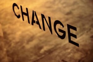 Text that says CHANGE in black bold font with cloud-cover and sunset. 